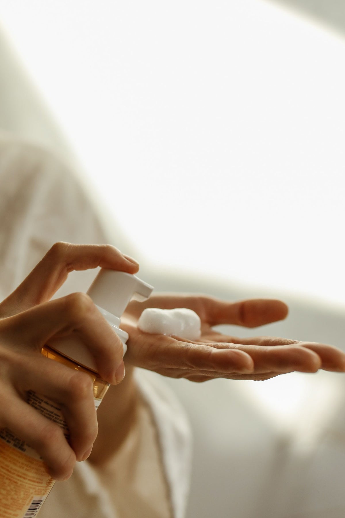 Cleanser foam dispensed into the palm during a skincare routine